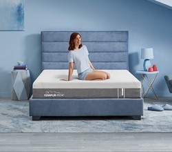 woman sitting on a cloud mattress smiling